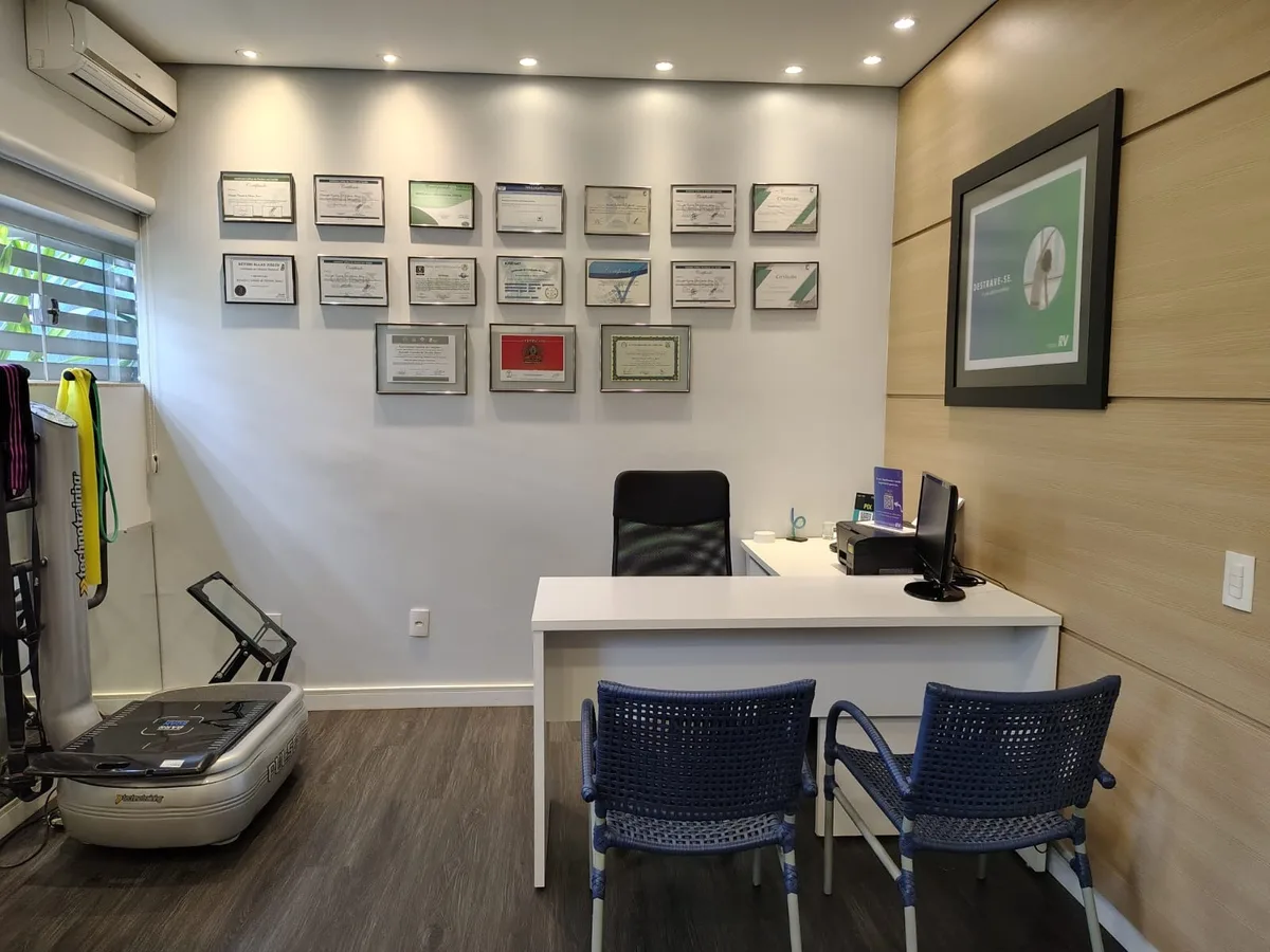 Consultório de avaliação da Proforma | Instituto RV em Uberaba, com a parede de certificações da equipe